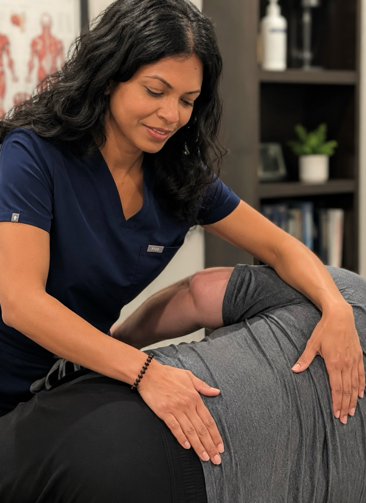 Dr. Nelly Singh, DO performing paraspinal soft tissue osteopathic treatment on a patient in her office